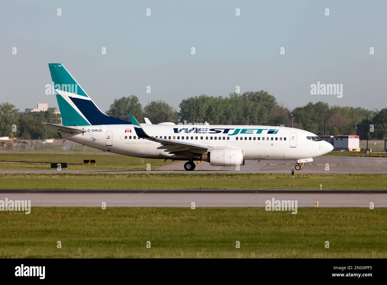 A WestJet Airlines Boeing 737-700 taxiing at Montreal Pierre Elliott Trudeau Int'l Airport. WestJet has two direct subsidiaries: WestJet Encore, which operates the Bombardier Q400; and WestJet Link, which operates the Saab 340B Stock Photo