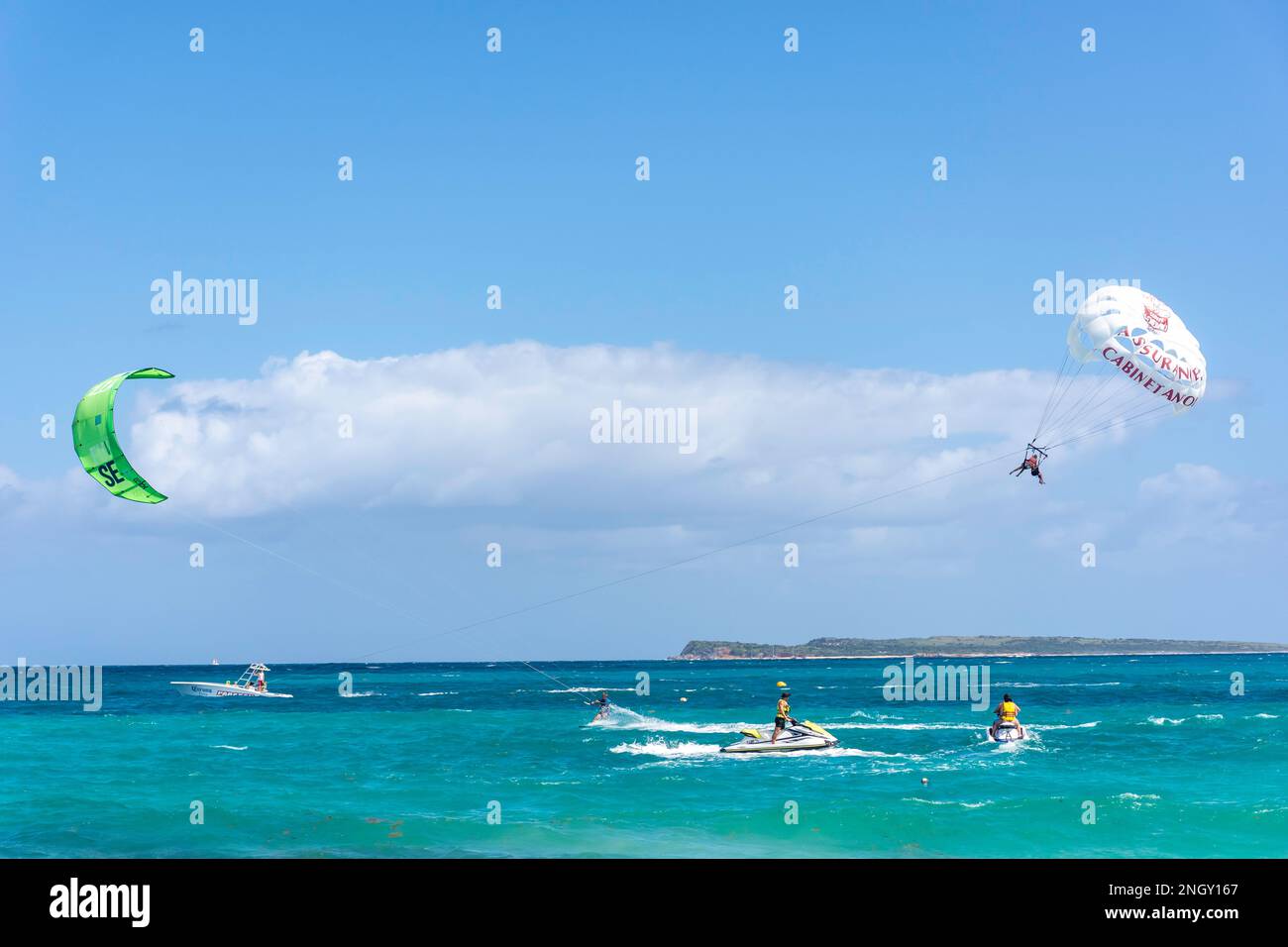 Man kite surfing and couple paragliding, Orient Bay (Baie Orientale), St Martin (Saint-Martin), Lesser Antilles, Caribbean Stock Photo