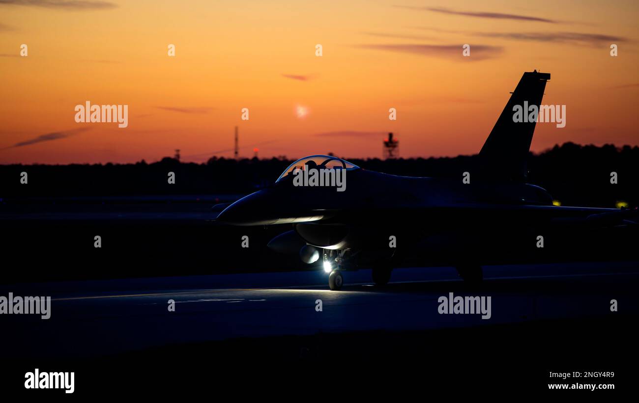 A U.S. Air Force F-16C Fighting Falcon pilot, from the 177th Fighter Wing of the New Jersey Air National Guard, taxis down a runway in preparation for a night flying mission Dec. 1, 2022, at the Atlantic City International Airport, Egg Harbor Township, New Jersey. The night flying was conducted to train pilots for safe and effective night operations. Stock Photo