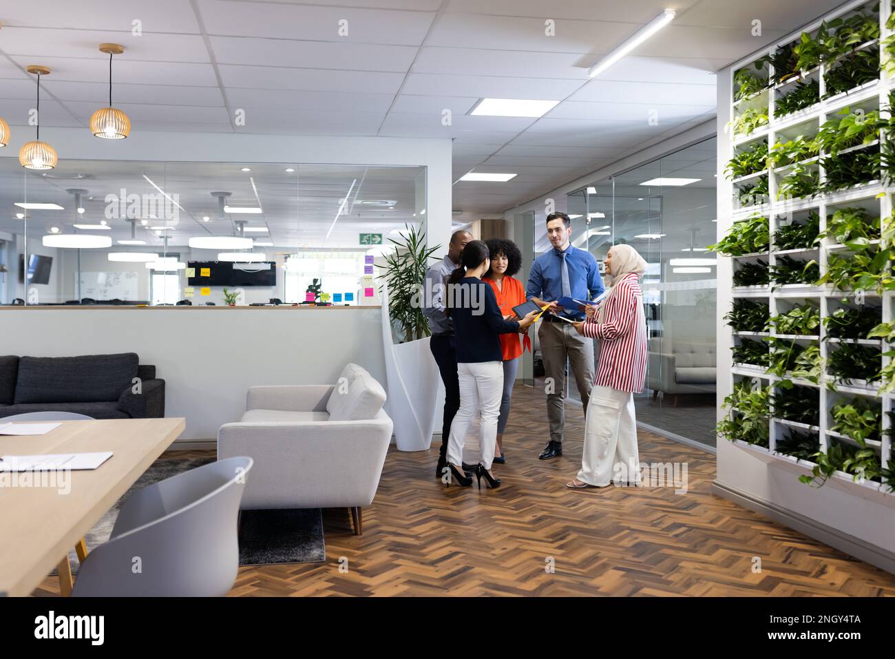 Happy diverse female and male businesspeople talking and working in ...