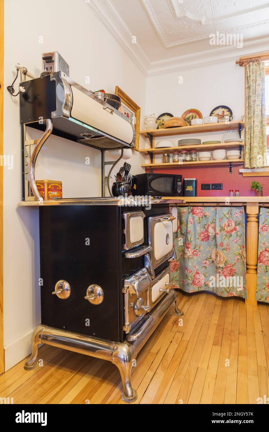 Elmira antique electric cooking stove in kitchen with birch wood