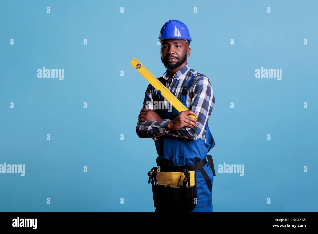 Construction worker holds ruler to make measurements, wears work ...