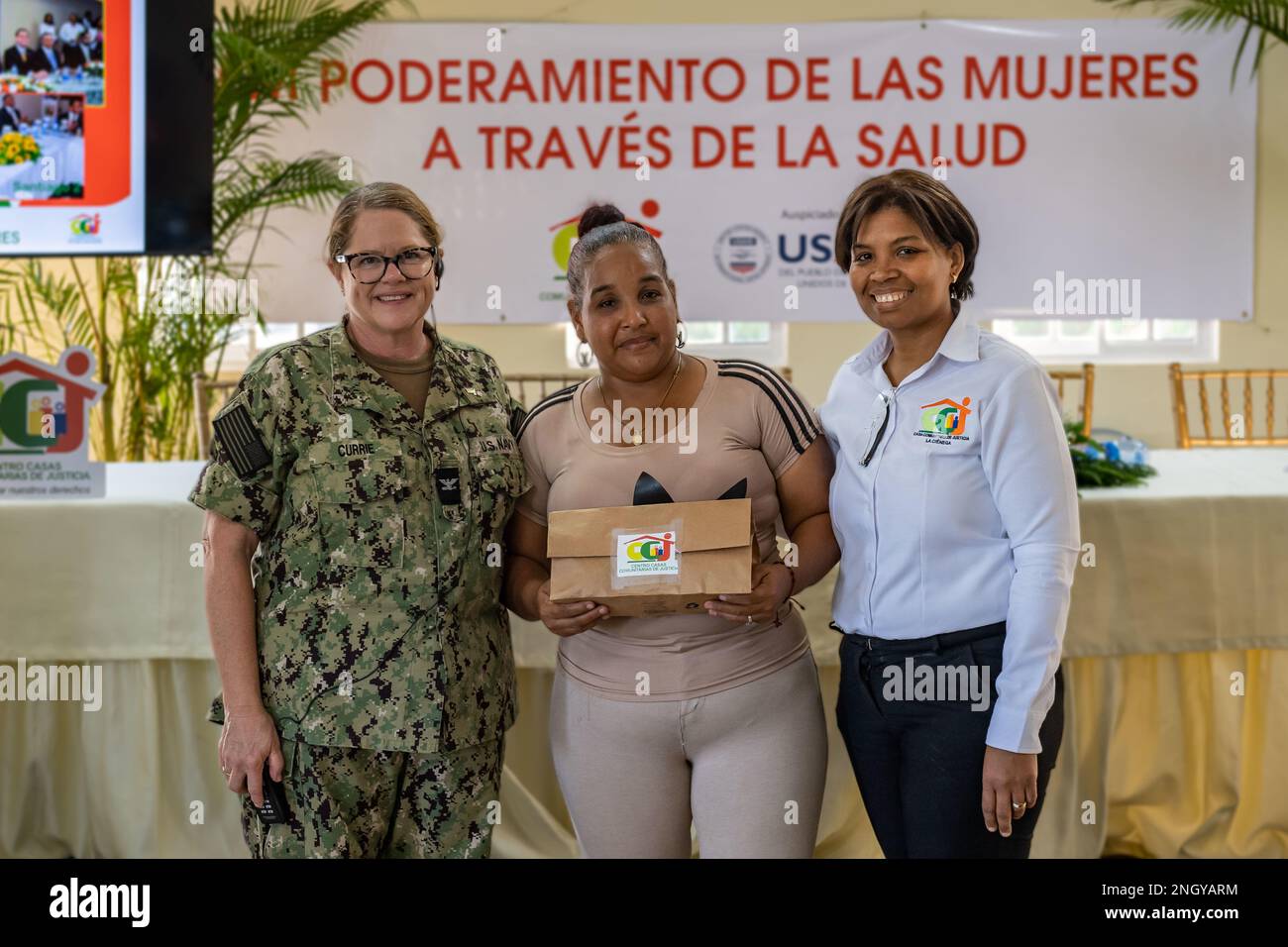 221201-N-LP924-1163 SANTO DOMINGO, Dominican Republic (Dec. 1, 2022) Capt. Carolyn Currie, from Lake George, New York, left, and Erica Valera, the manager of the Community Justice Center in La Ciénaga, Santo Domingo, right, present a hygiene kit to a community leader following a Women, Peace, and Security (WPS) community fair with locals as part of Continuing Promise 2022 at the Community Justice Center in Santo Domingo, Dec. 1, 2022. Continuing Promise 2022 is a humanitarian assistance and goodwill mission conducting direct medical care, expeditionary veterinary care, and subject matter exper Stock Photo