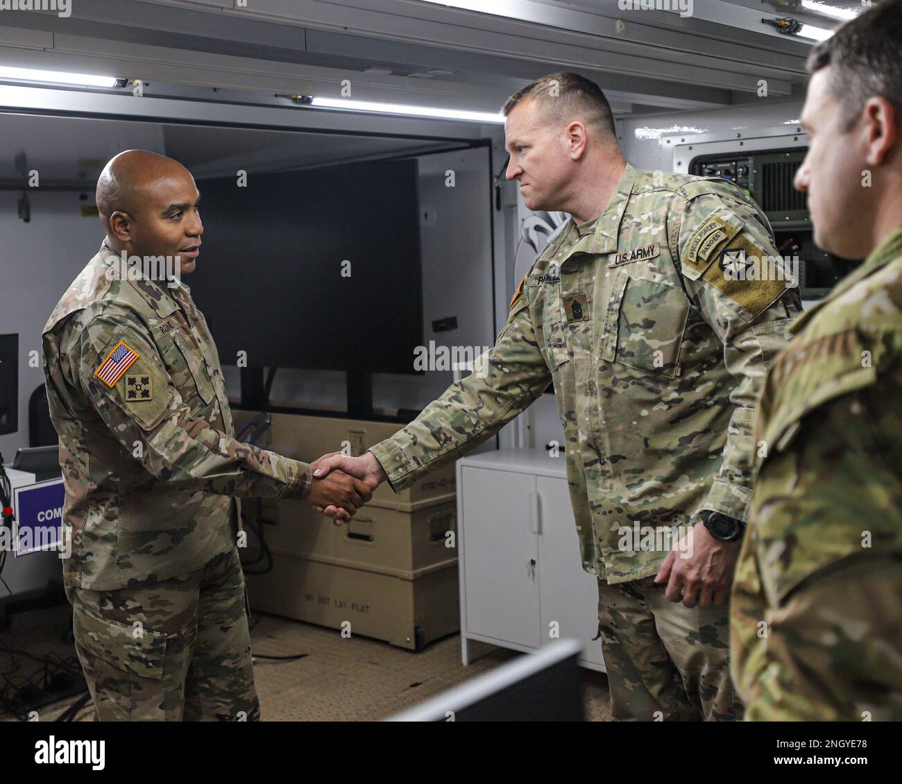 POZNAN, Poland - U.S. Army Brig. Gen. Monté Rone, Deputy Chief of Staff for Operations Multinational Corps Northeast, left, shakes the hand of Sgt. Maj. Timothy Parnell, sergeant major of operations, V Corps (Forward), Dec. 1, 2022, Camp Kosciuszko, Poland. Leaders and officers from MNCNE visited V Corps’ Forward Headquarters to observe the compatibility between U.S., MNCNE, and NATO communication systems. Stock Photo