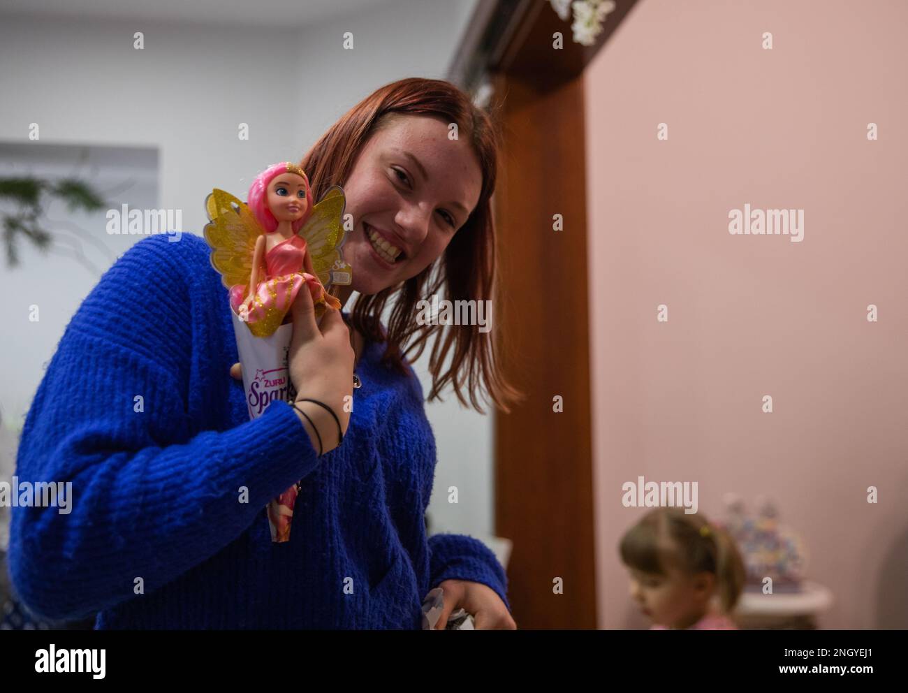 A teenager, housed at the Dom Dziecka P.W. Sw. Jozefa Zgromadzenia Sióstr Elżbietanek, the Orphanage of St. Joseph of the Congregation of the Elizabethan Sister, smiles after unwrapping a gift during an exchange held in Bolesławiec, Poland, Dec. 1, 2022. The gifts were donated to children living at the orphanage by Soldiers assigned to the 1st Infantry Division who are working in communities of NATO allies and regional security partners while providing combat-credible forces to V Corps, America’s forward deployed corps in Europe. Stock Photo
