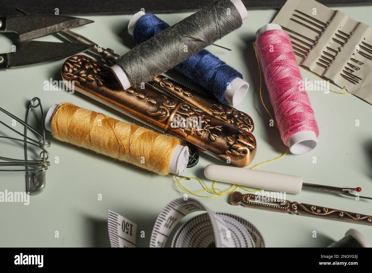 A jumble of typical sewing objects on a blue surface clara Stock Photo