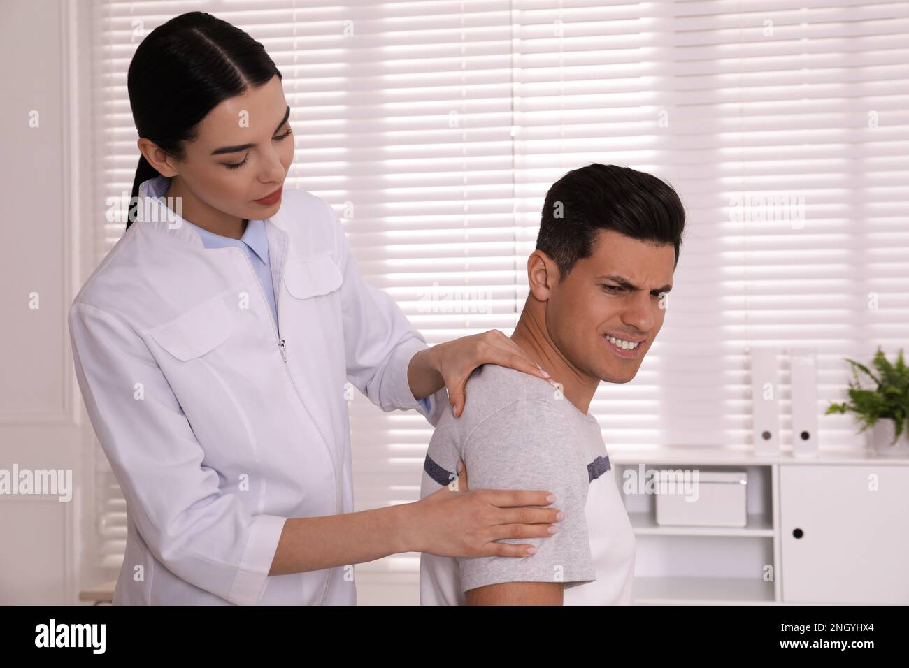 Doctor examining man with shoulder pain in hospital Stock Photo Alamy