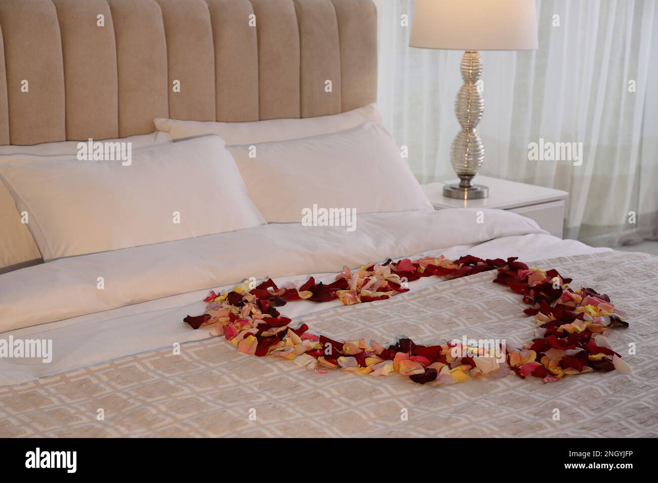 Beautiful heart of rose petals on bed in room Stock Photo Alamy