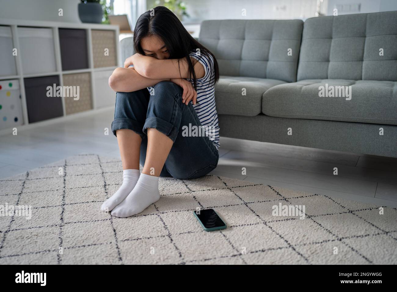 Lonely sad asian woman suffering on floor looks devastated mental trouble bad relationship breakup. Stock Photo