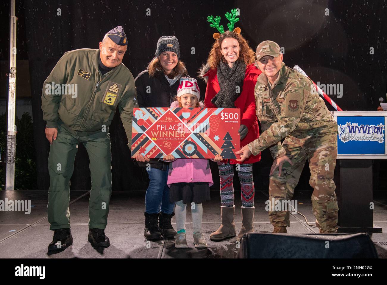 U.S. Air Force Brig. Gen. Tad Clark, 31st Fighter Wing commander, far right, and Italian Air Force Lt. Col. Riccardo Isoli, operations chief, far left, present the first place for the holiday card decoration contest prize to representatives from the 555th Fighter Squadron, middle, during the Wyvern Wonderland holiday event at Aviano Air Base, December 2, 2022. Wyvern Wonderland provided a host of events and activities to help families connect with each other and thrive during their time in Italy. Stock Photo