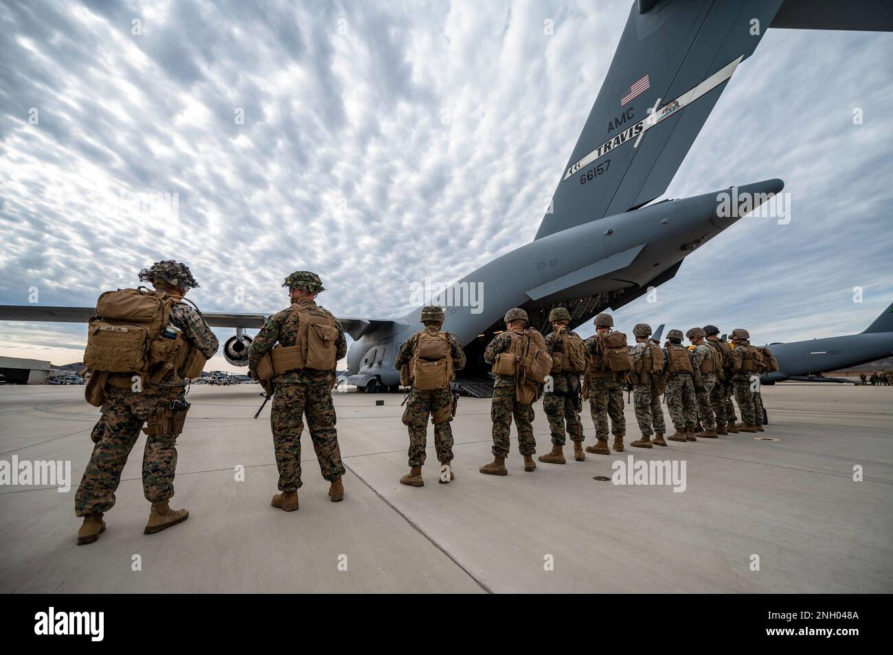 U.S. Marines with Battery Q, 5th Battalion, 11th Marine Regiment, prepare to board a C-17 Globemaster III during exercise Steel Knight, at Camp Pendleton, California, Dec. 2, 2022. The 21st Airlift Squadron transported 15 Marines and approximately 68,000 pounds of equipment during their annual exercise which included live-fire training in controlled environments. Stock Photo