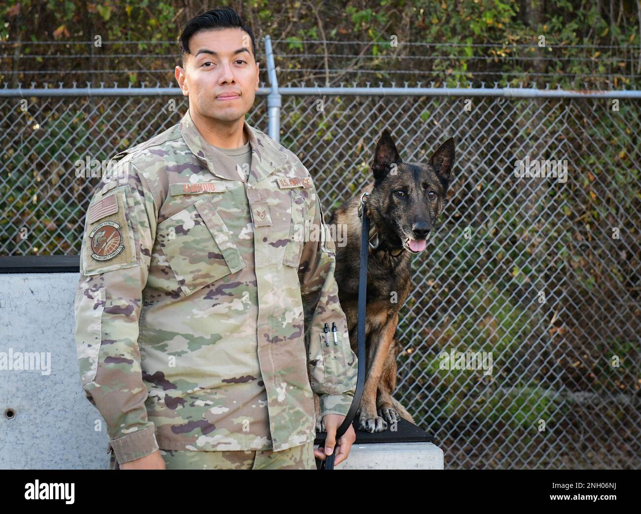 Staff Sgt. David Zamudio and Military Working Dog Robo, both assigned to the 78th Security Forces Squadron, pose for a portrait shortly after Robo’s retirement ceremony Dec. 2, 2022, at Robins Air Force Base, Georgia. Robo, who served for eight years as a working dog, was retired due to a hip injury that prevents him from performing his duties and was officially adopted by Zamudio. (Air Force photo by Alexandra Shea) Stock Photo