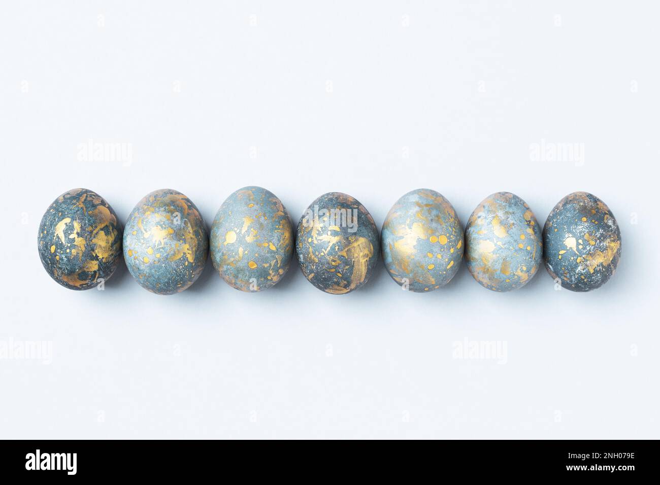Blue and gold Easter eggs in row. Easter background, greeting card, copy space, flat lay, Stock Photo