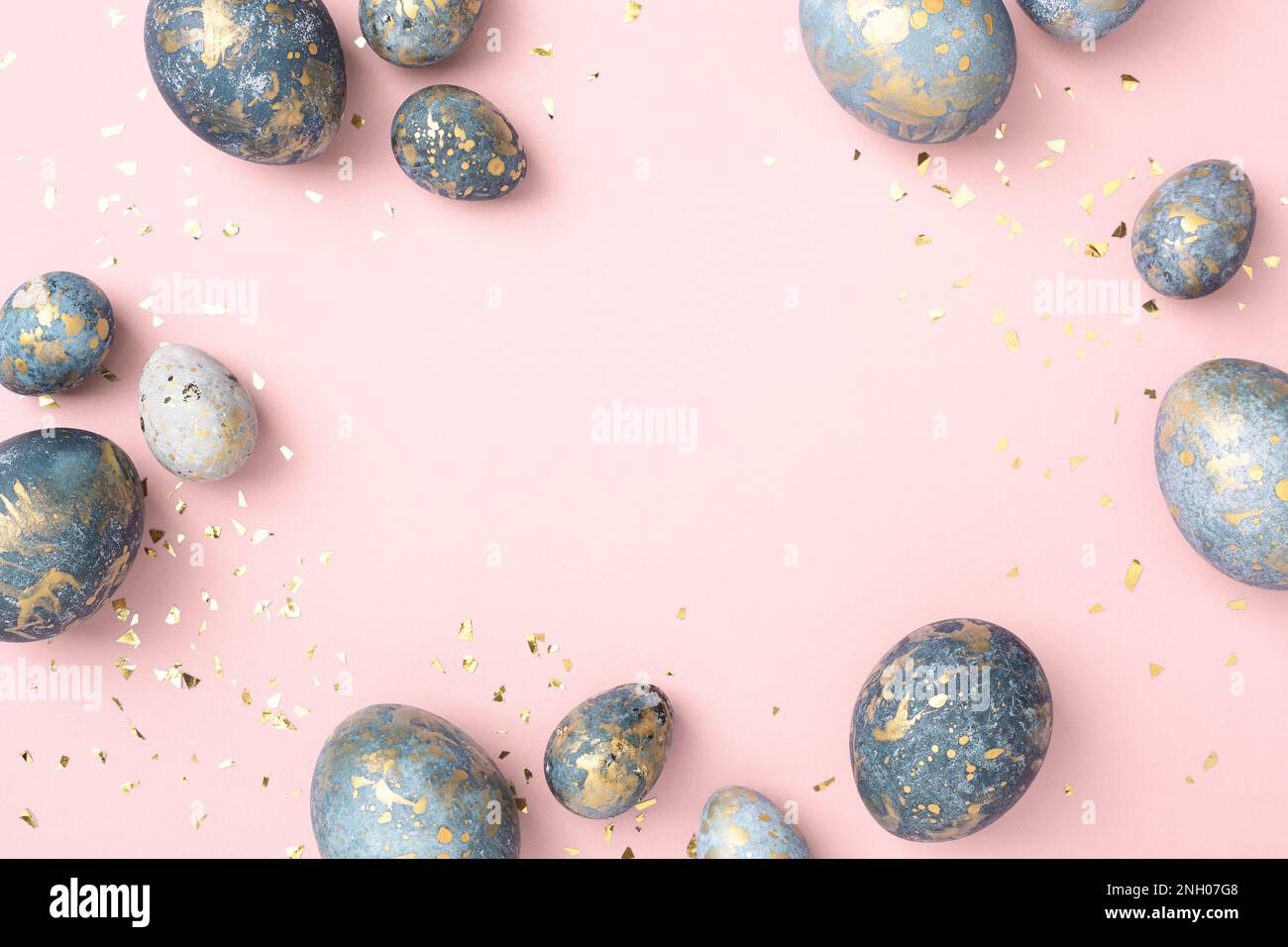 Blue Easter eggs frame, pink background with gold confetti. Chic Easter greeting card, copy space. Stock Photo