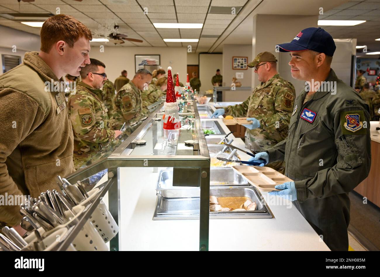 U.S. Air National Guard Lt. Col. Brandon Eskam, 114th Fighter Wing vice commander, serves lunch to Airmen at Dutch’s Inn dining facility at Joe Foss Field, S.D., Dec. 3, 2022. Each year, 114th FW leadership takes the opportunity to serve lunch to the unit members. Stock Photo