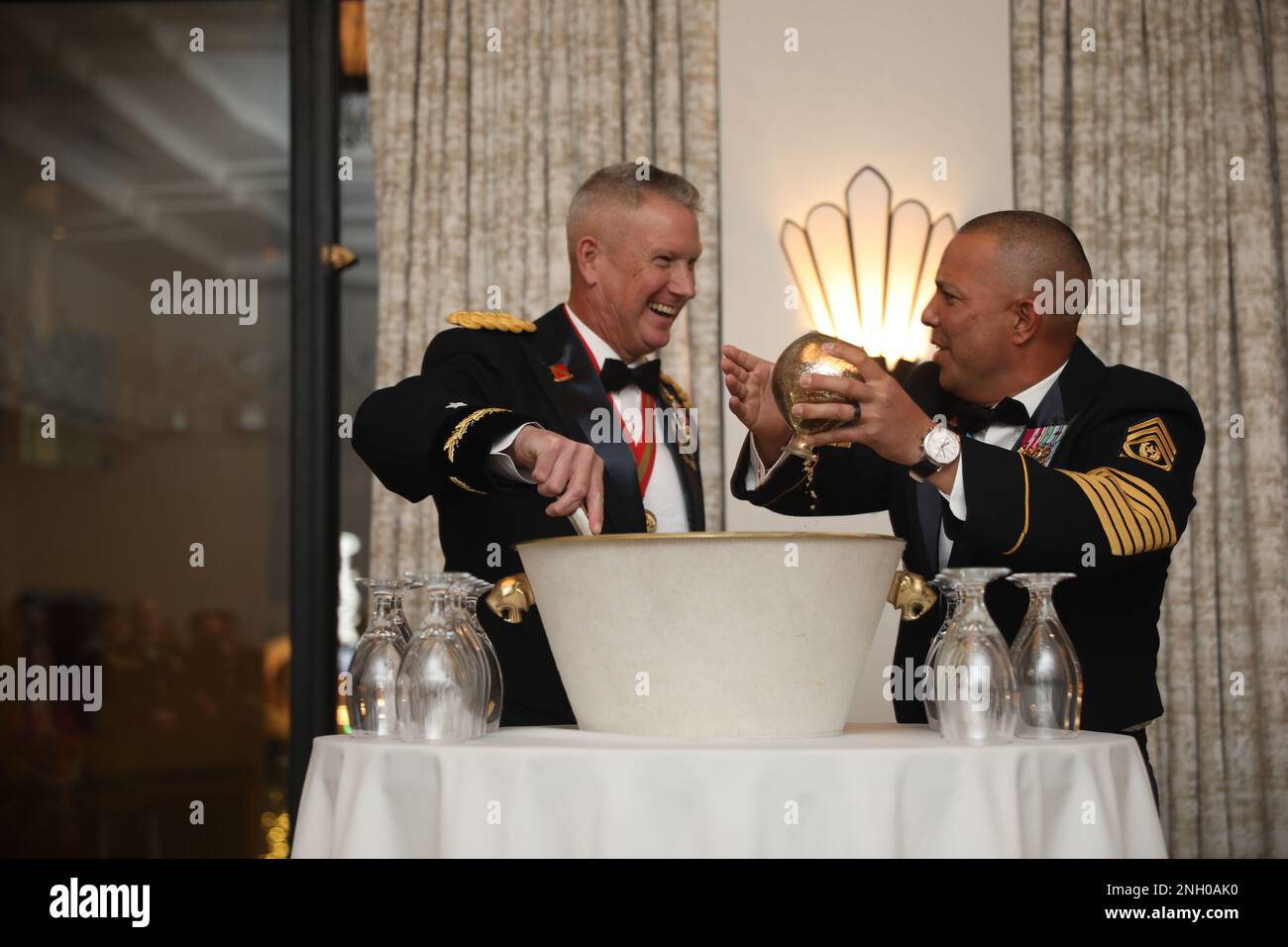 The 32d AAMDC command team contributes a charge of 'sand', brown sugar, to the ceremonial grog during the Saint Barbara's Social, December 3rd at the Plaza Hotel in El Paso, Texas.  Grog ceremonies are a military ball tradition and normally involve contributing any number of spirits or odd substances to a large punch bowl and mixing them for the purpose of toasts. Stock Photo