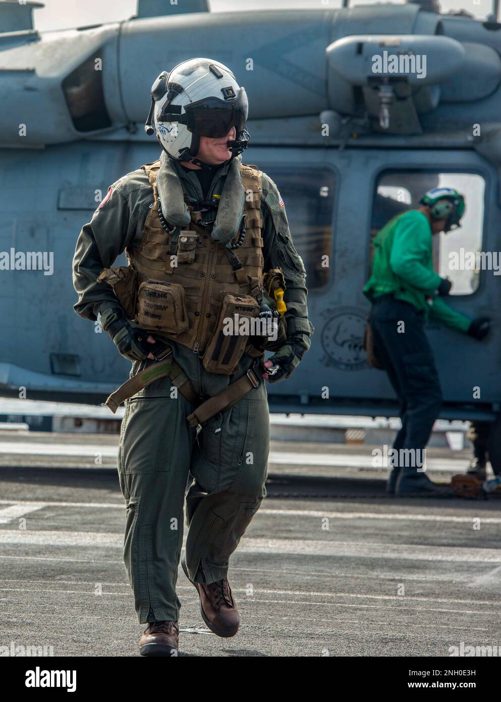 221204-N-UF592-2411 PHILIPPINE SEA (Dec. 4, 2022) Capt. Daryle Cardone, commanding officer of the U.S. Navy’s only forward-deployed aircraft carrier, USS Ronald Reagan (CVN 76), disembarks from an MH-60S Seahawk, attached to the Golden Falcons of Helicopter Sea Combat Squadron (HSC) 12, in the Philippine Sea, Dec. 4. HSC 12, originally established as Helicopter Anti-Submarine Squadron (HS) 2 on March 7, 1952, is the oldest active operational Navy helicopter squadron. Ronald Reagan, the flagship of Carrier Strike Group 5, provides a combat-ready force that protects and defends the United States Stock Photo