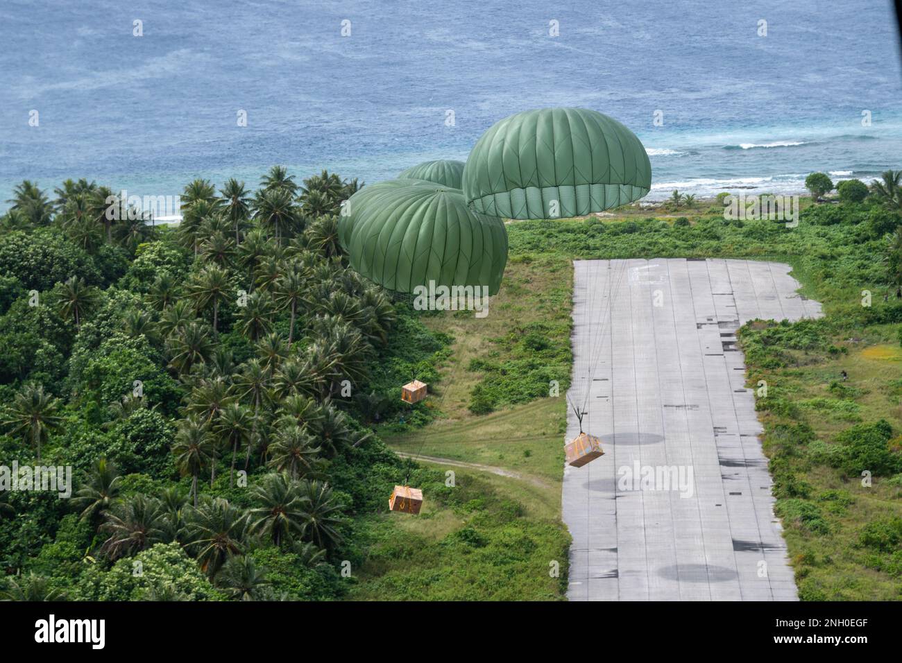 Bundles descend from a U.S. Air Force C-130J Super Hercules assigned to the 36th Expeditionary Airlift Squadron at Ulithi, Federated States of Micronesia, Dec. 4, 2022. Loadmasters from the 36 EAS prepared and trained for the safe delivery of each bundle, with many of the bundles weighing over 300 pounds. The aircraft, call sign Santa 11, delivered 14 bundles to the eastern Caroline Islands, included Asor, Falalop, and Fais islands. OCD is the longest-running Department of Defense humanitarian and disaster relief mission. Each year, the USAF partners with countries in the Pacific Air Forces ar Stock Photo