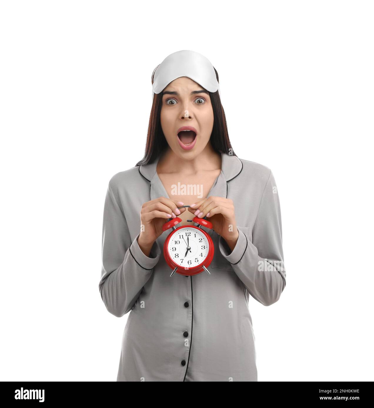Emotional overslept woman with alarm clock on white background. Being