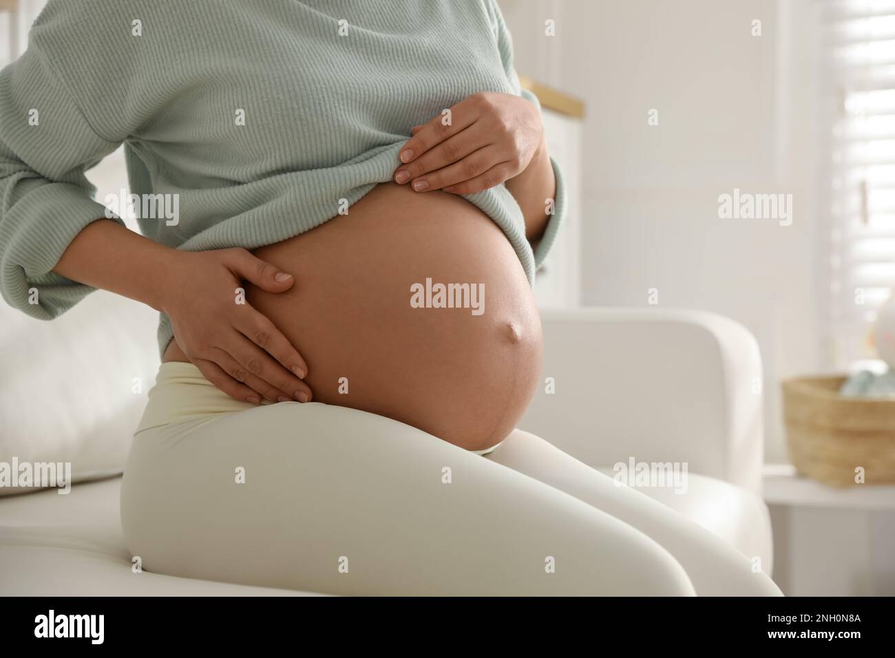 Pregnant woman at home, closeup. Choosing baby name Stock Photo