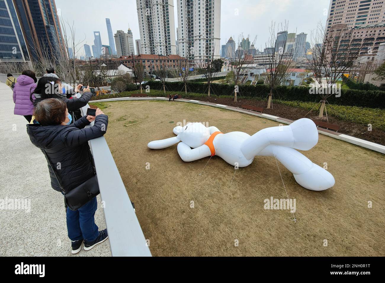 A giant rabbit statue lying on the lawn attract people to take photos