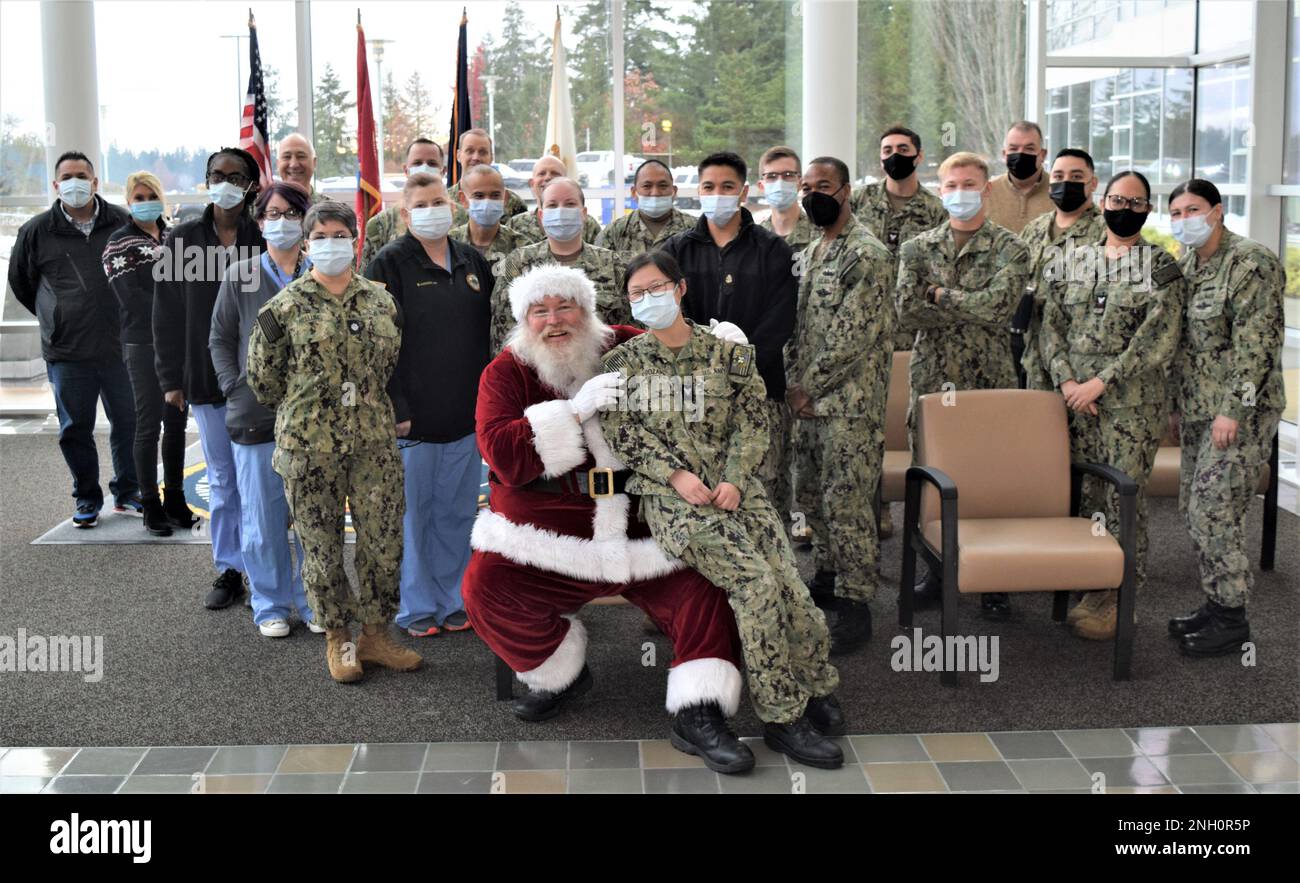 Festive Gathering to Deck the Halls...Naval Hospital Bremerton converge around a surprise visit by Santa for an impromptu photo-op as part of the command's Tree Lighting ceremony, Dec. 5, 2022, a time-honored and hallowed tradition bringing staff members and families together to share the season and recognize those who won’t be home due to operational readiness commitments (Official Navy photo by Douglas H Stutz, NHB/NMRTC Bremerton public affairs officer). Stock Photo