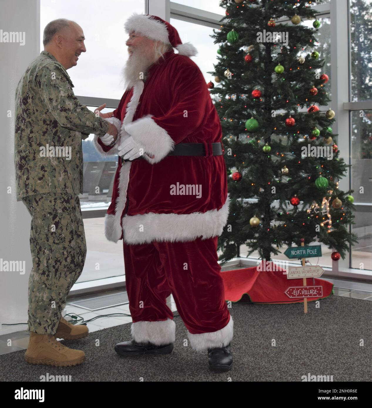A welcoming Santa surprise at Naval Hospital Bremerton...Capt. Patrick Fitzpatrick, NHB director and Navy Medicine Readiness Training Command Bremerton commanding officer extends seasonal greetings with Santa, ably portrayed by Cris Larsen, standup comedian and noted local civic leader active with the Bremerton Chamber of Commerce Armed Forces Festival at the command's annual Tree Lighting ceremony, Dec. 5, 2022 (Official Navy photo by Douglas H Stutz, NHB/NMRTC Bremerton public affairs). Stock Photo