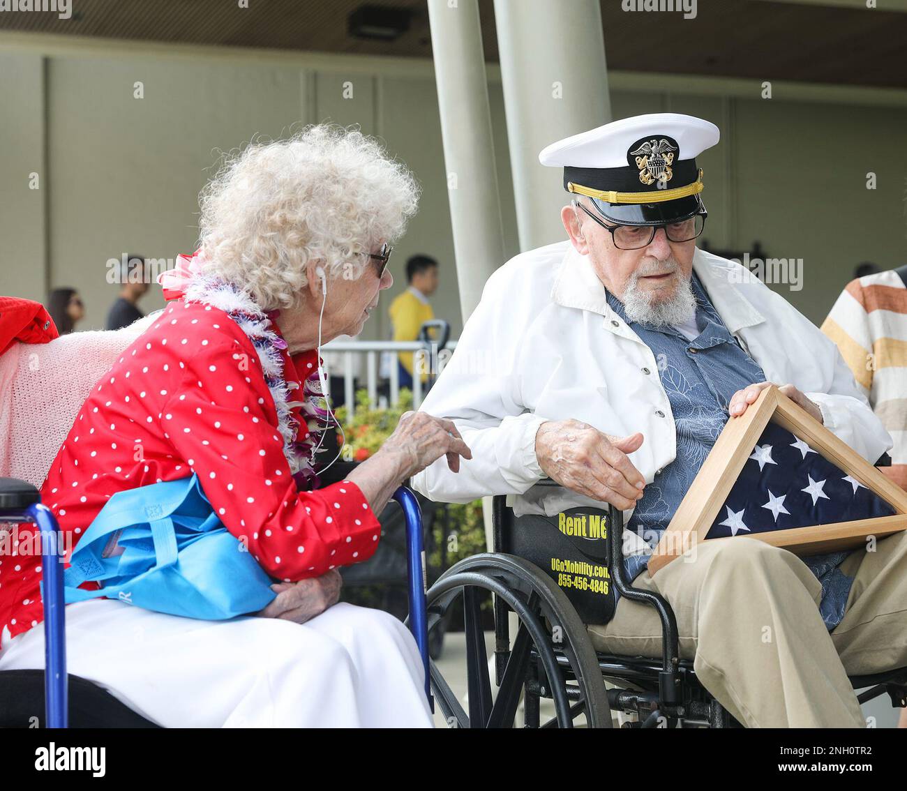 PEARL HARBOR, (Dec. 5, 2022) Former Navy musician’s mate and honorary bandmaster Ira 'Ike' Schaba, shows Rosie the Riveter, Marian Sousa, a flag that was presented during a performance by the U.S. Pacific Fleet Band, which performed for World War II veterans and Pearl Harbor visitors during an 81st Anniversary Pearl Harbor Remembrance concert at the Pearl Harbor Visitor Center. Dec. 7, 2022, marks the 81st year since the attacks on Pearl Harbor and Oahu. The U.S. military, State of Hawaii and National Park Service are hosting a series of remembrance events throughout the week to honor the cour Stock Photo
