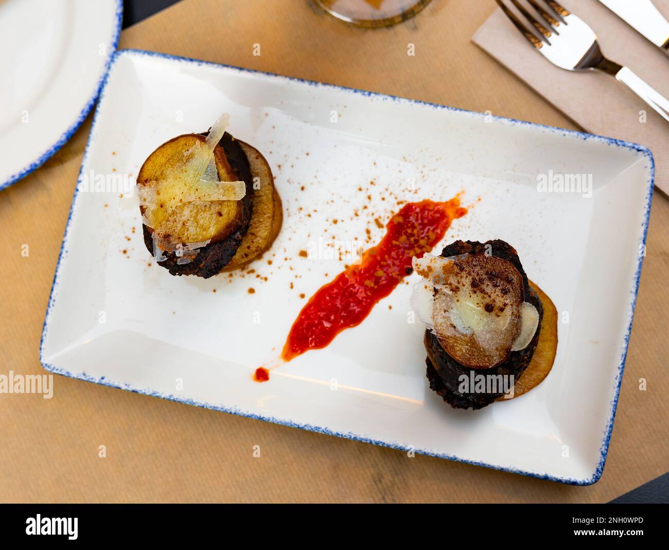 Spanish timbale of morcilla with caramelized pears and cheese Stock