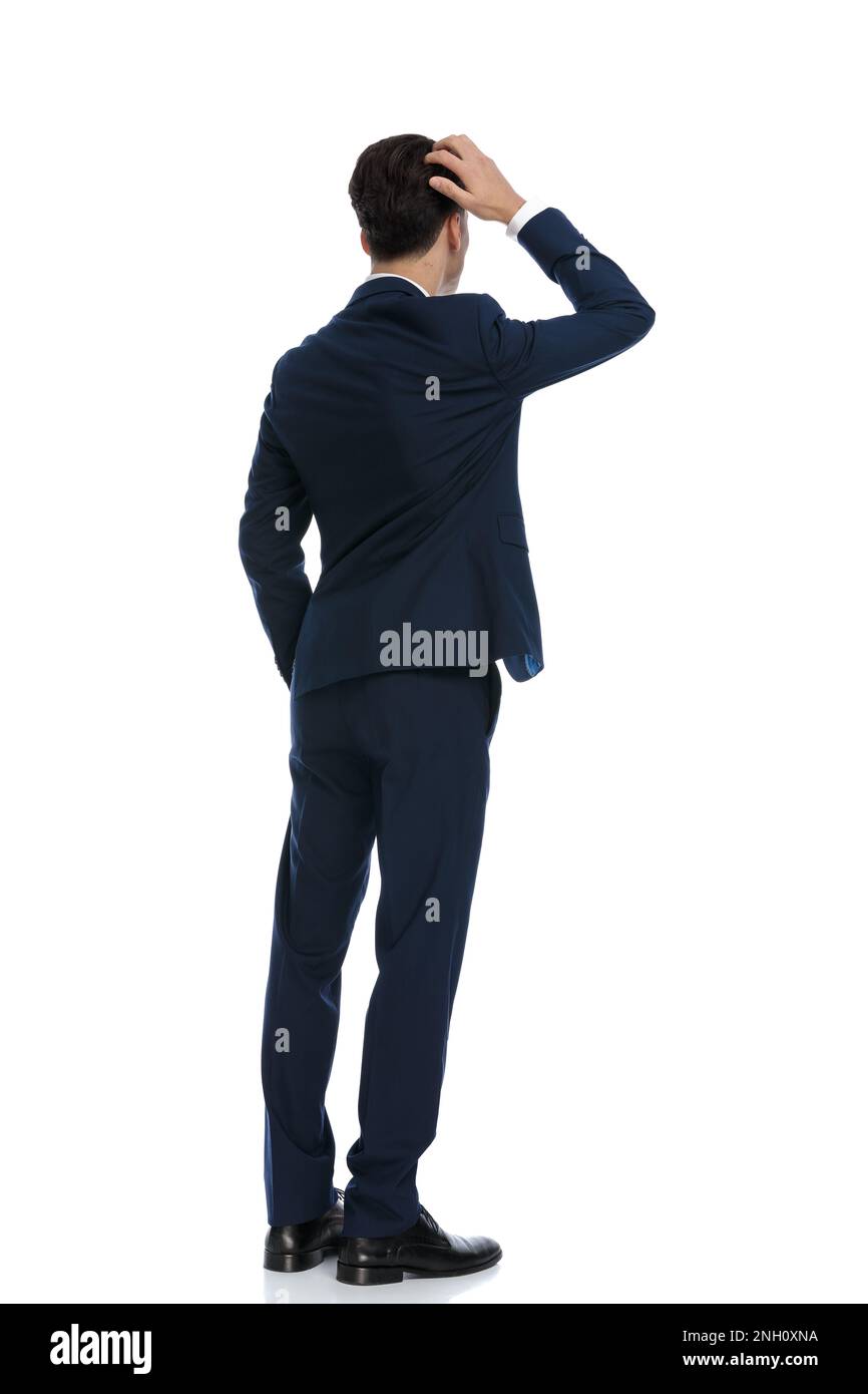 elegant businessman scratching his head and feeling confused, wearing a suit and tie against white background Stock Photo