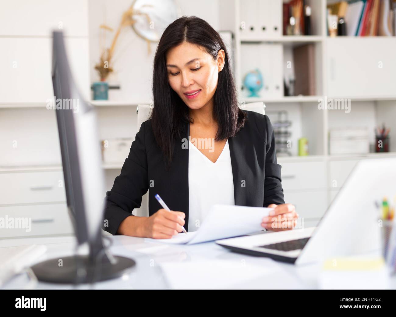 Young asian woman working in office and signs documents Stock Photo