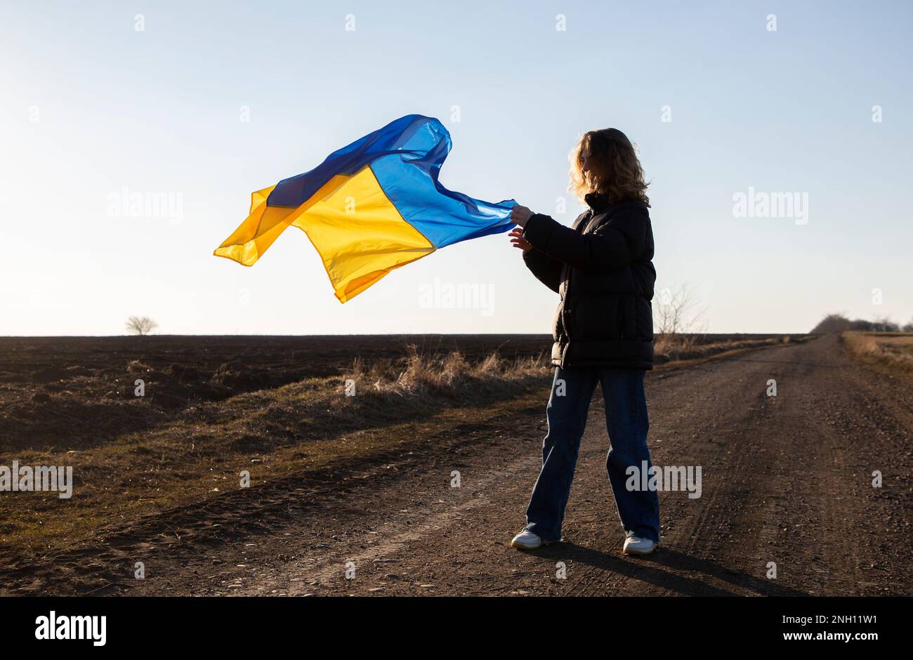 young woman with waving yellow and blue Ukrainian flag. request for help to Ukraine. independence, freedom. Support Ukraine. Stop the war. Faith in vi Stock Photo