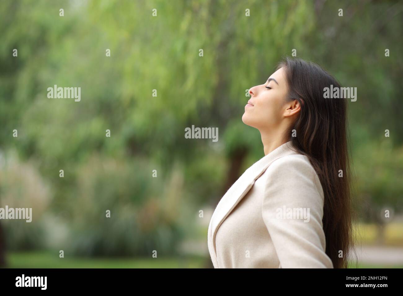 Side view portrait of a woman breathing in a park in winter Stock Photo