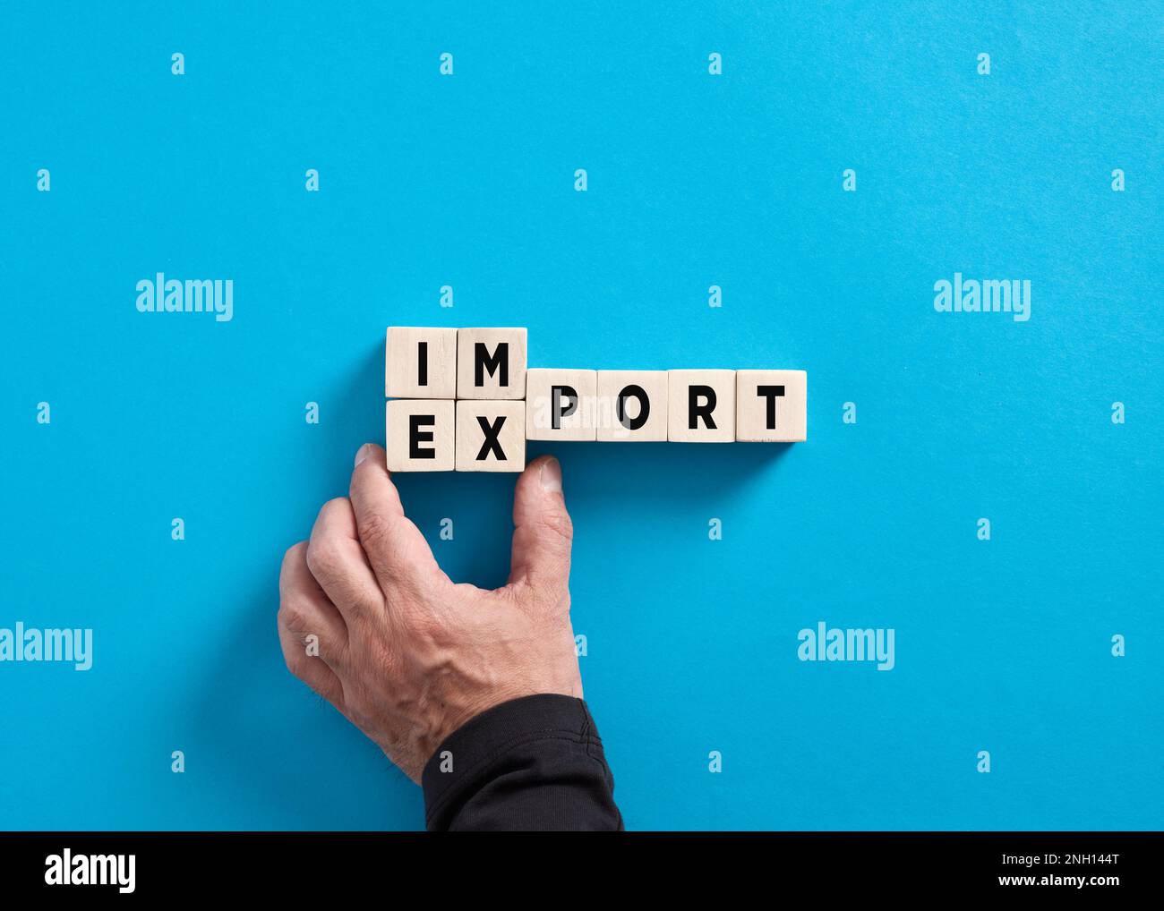 Male hand changes the word import to export on blue background. Industrial trade relations. Importing and exporting strategies. Business concept Stock Photo