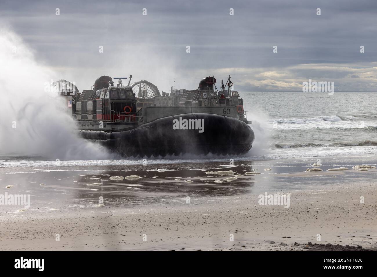 A U.S. Navy landing craft air cushion (LCAC) with Assault Craft Unit 4, transports a high mobility multipurpose wheeled vehicle during a training exercise with 2d Light Armored Reconnaissance Battalion, 2d Marine Division, on Camp Lejeune, North Carolina, Dec. 6, 2022. The main purpose of an LCAC is to transport weapons systems, equipment, cargo and personnel of the assault elements of the Marine Air-Ground Task Force from ship-to-shore and across the beach. Stock Photo