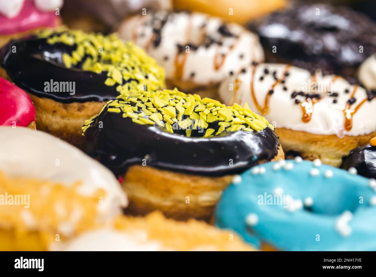 Delicious donuts of different flavors on paper close up Stock Photo - Alamy