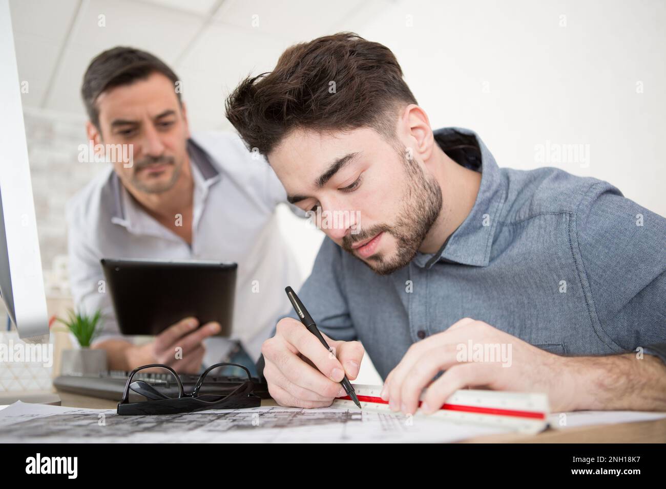 supervisor assessing architect drawing up blueprints Stock Photo - Alamy