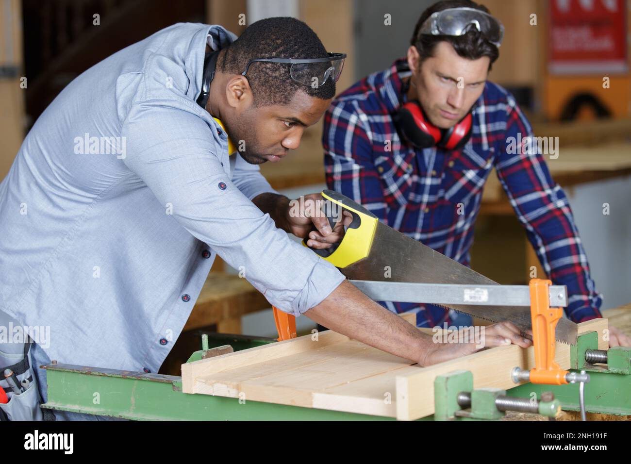 men using hand saw to cut wood in a Stock Photo Alamy