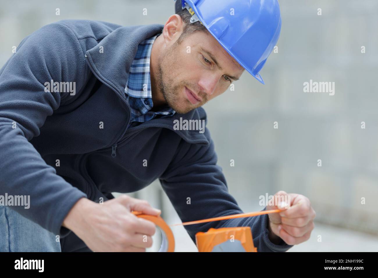 Builders Using Measure builder measures with tape m Stock Photo - Alamy