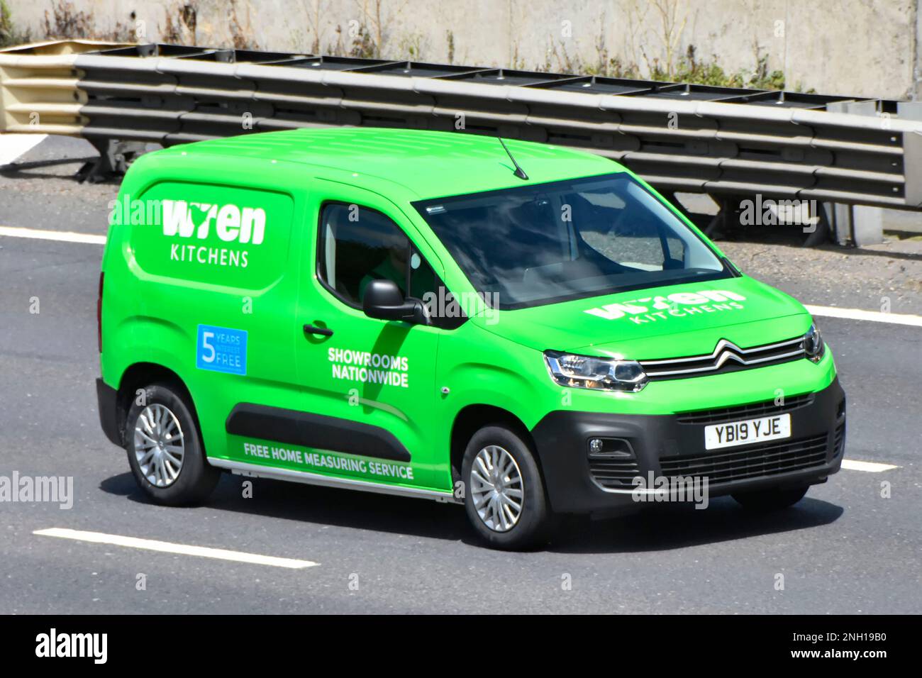 Wren Kitchens supply and fit joinery business operative inside front & side view green Citroen van driving along M25 motorway road in Essex England UK Stock Photo