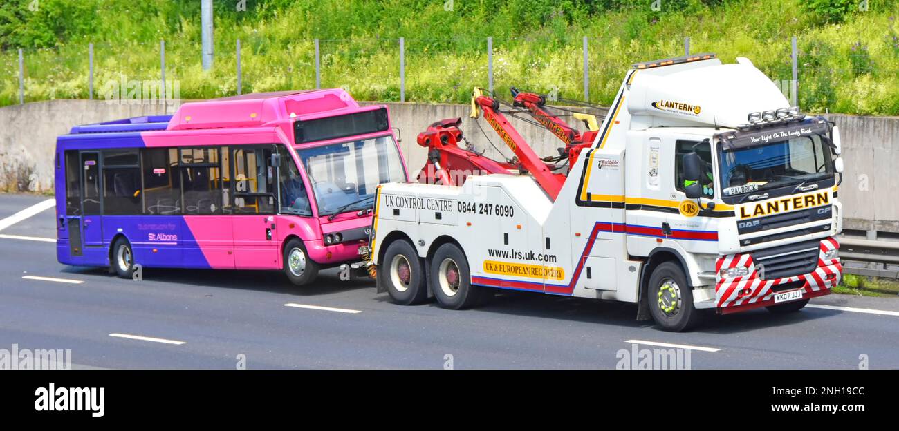 Heavy commercial DAF CF breakdown lorry hgv truck a specialist business vehicle towing St Albans public transport Uno bus colour M25 UK motorway road Stock Photo