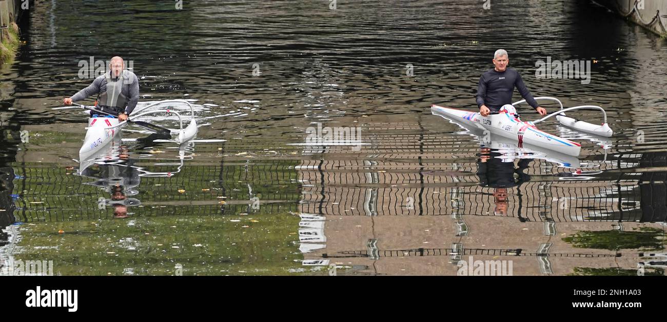 Aerial view two male canoeists paddling in Italian Allwave Vanguard outrigger canoes on still waters of River Can City of Chelmsford Essex England UK Stock Photo