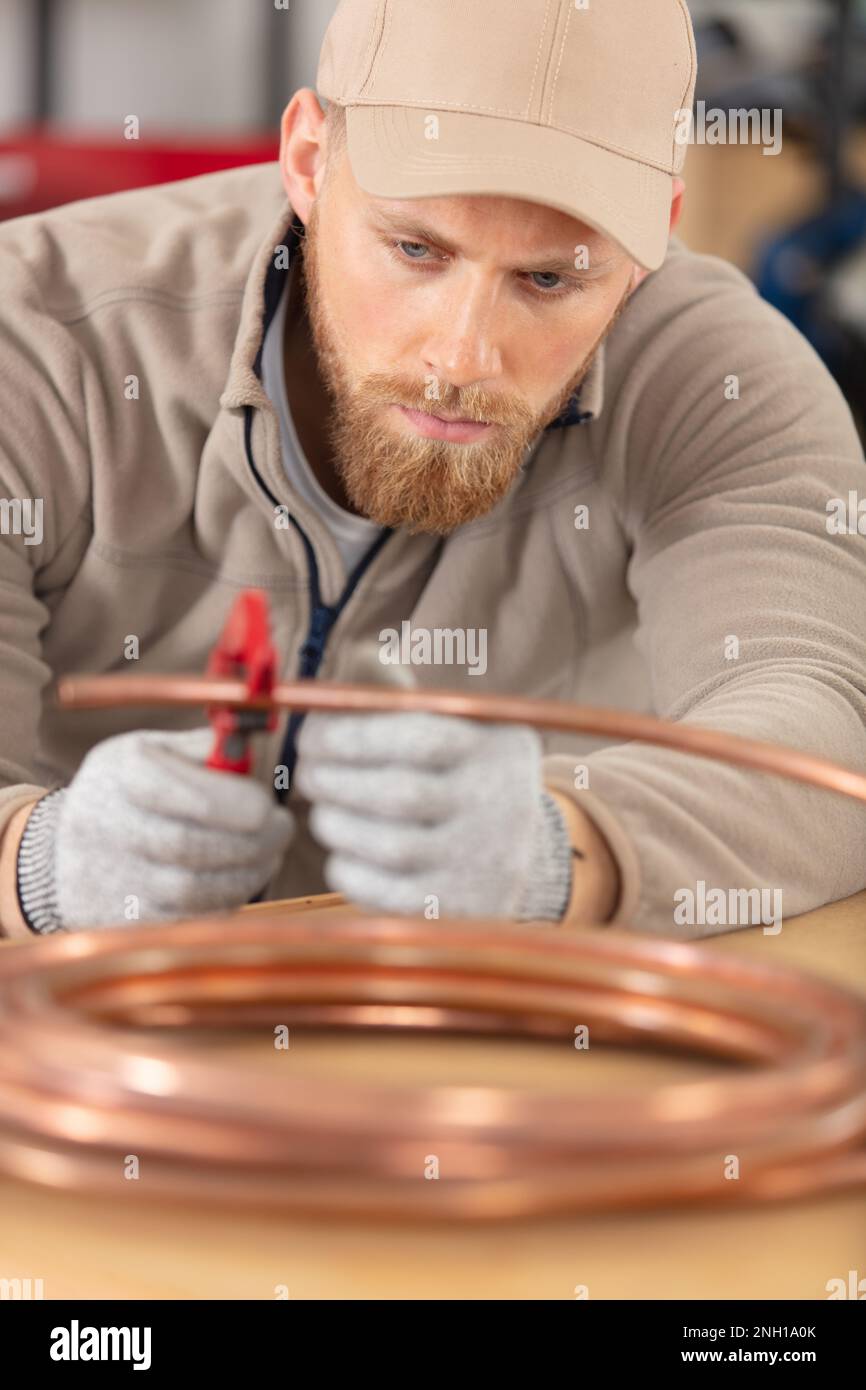 concentrated plumber cutting copper pipe Stock Photo Alamy