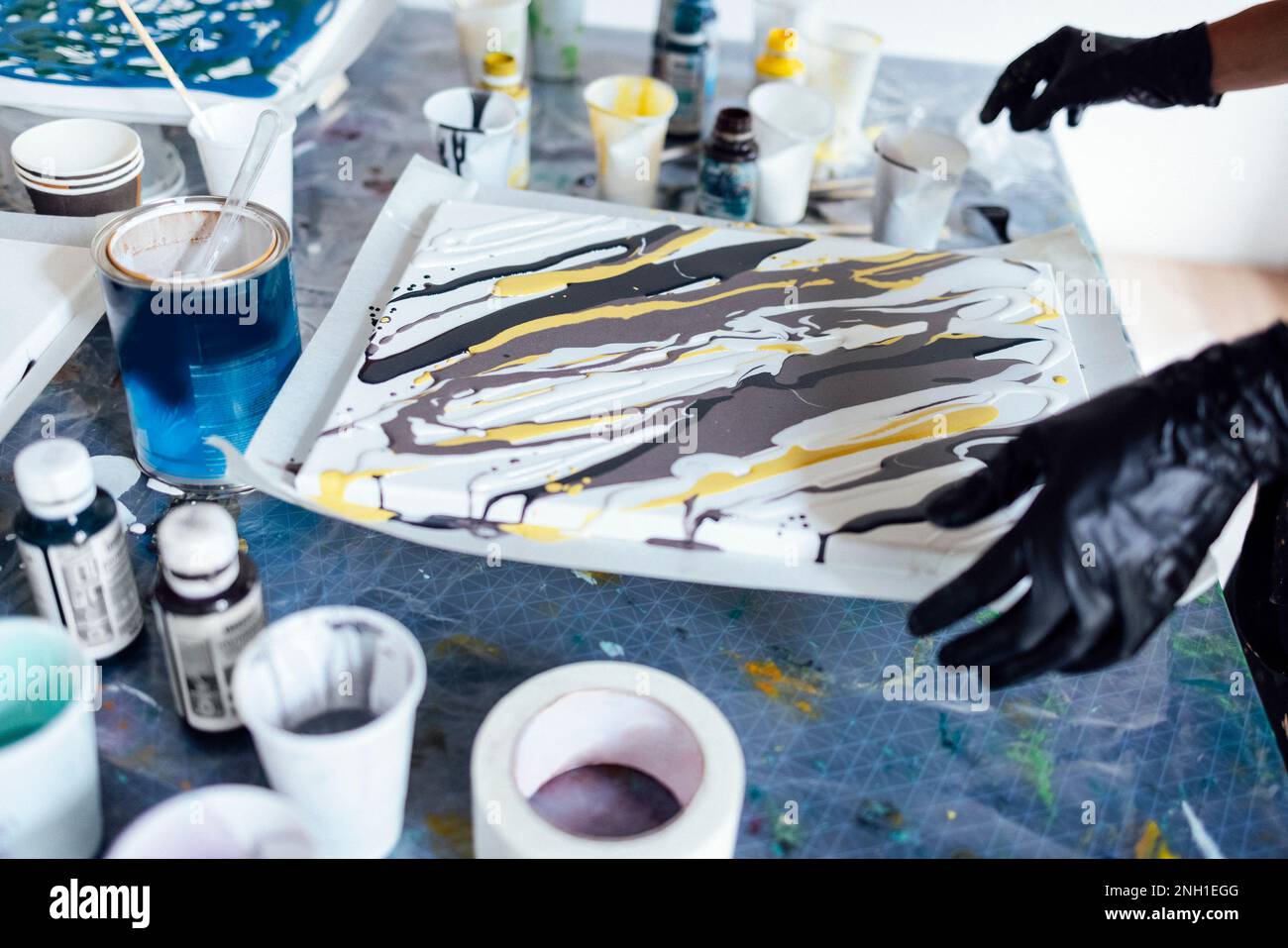 Painting tutorial. Young white girl in the gloves paint with liquid