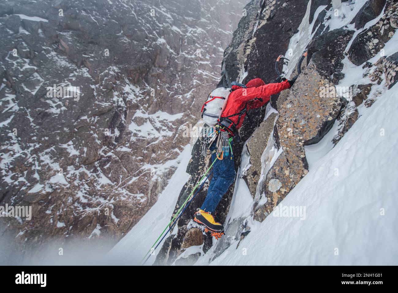 Mountaineer climbing rock and ice wall in snow Stock Photo - Alamy