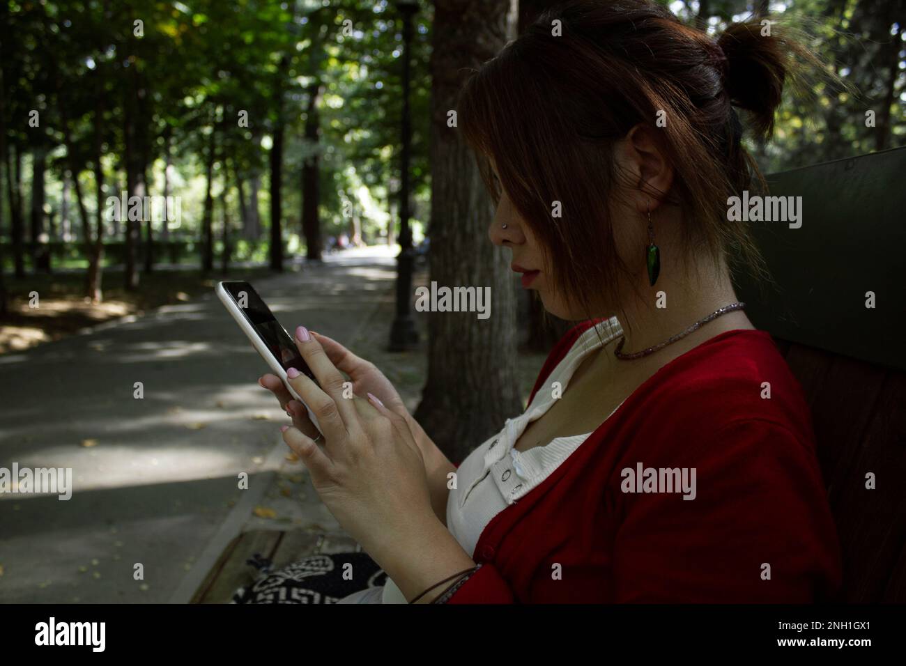 Woman sitting in the street with a smartphone Stock Photo