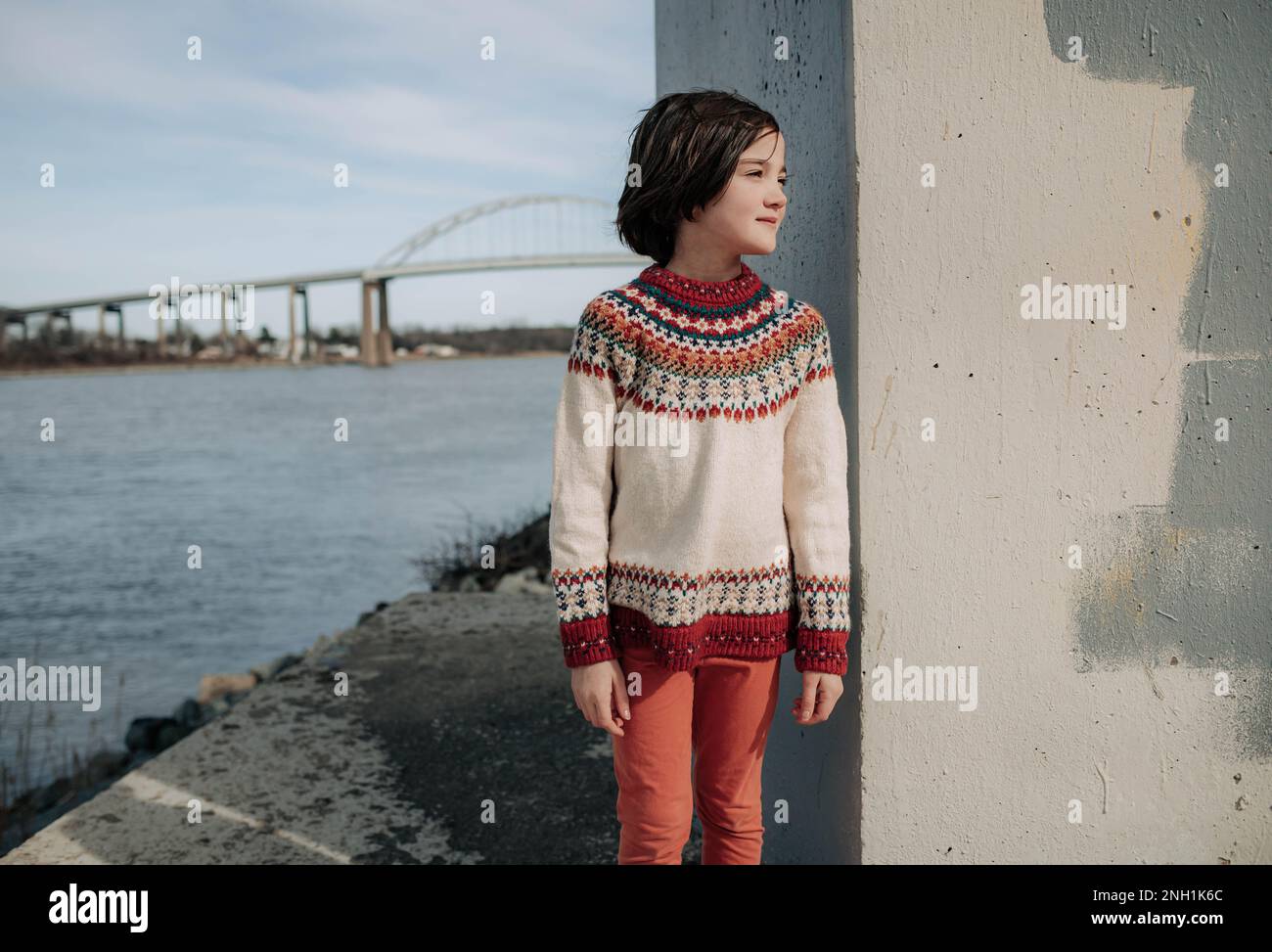 girl smiling under bridge with bridge behind her Stock Photo