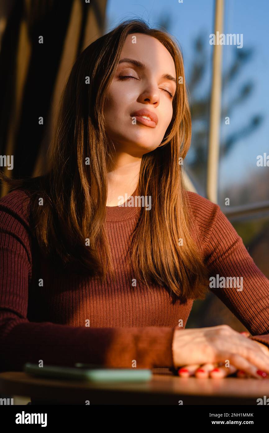 Portrait of a beautiful young girl with closed eyes illuminated by ...