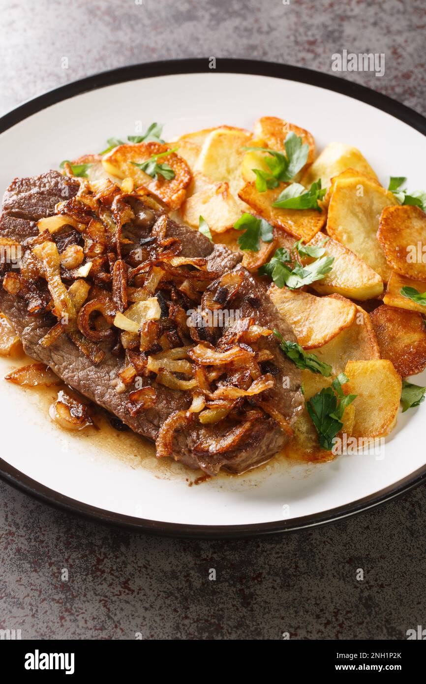 Traditional Zwiebelrostbraten German dryaged steak with onion and sauce served with fried