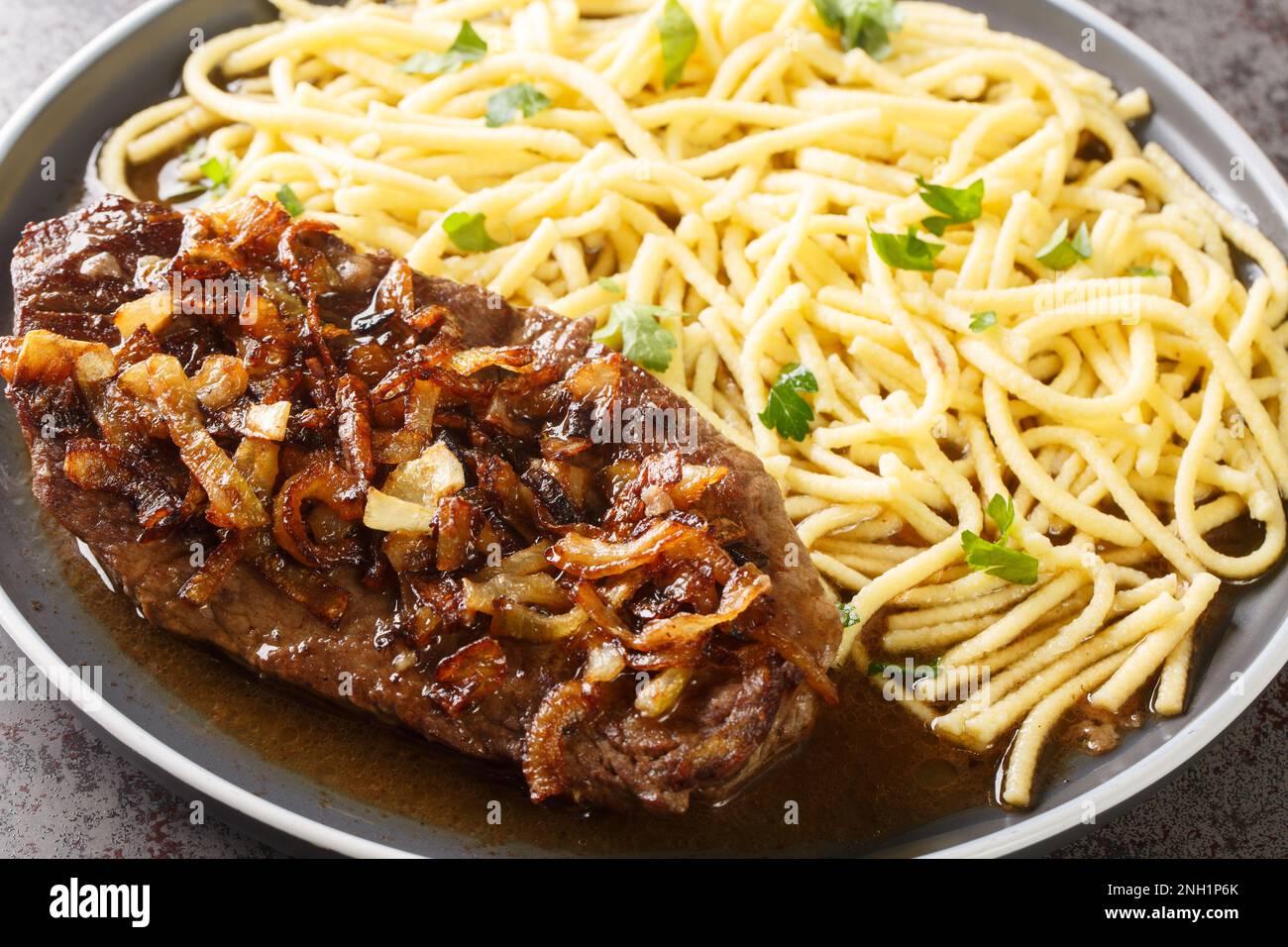 Zwiebelrostbraten onion topped roast beef with gravy and spaetzle ...